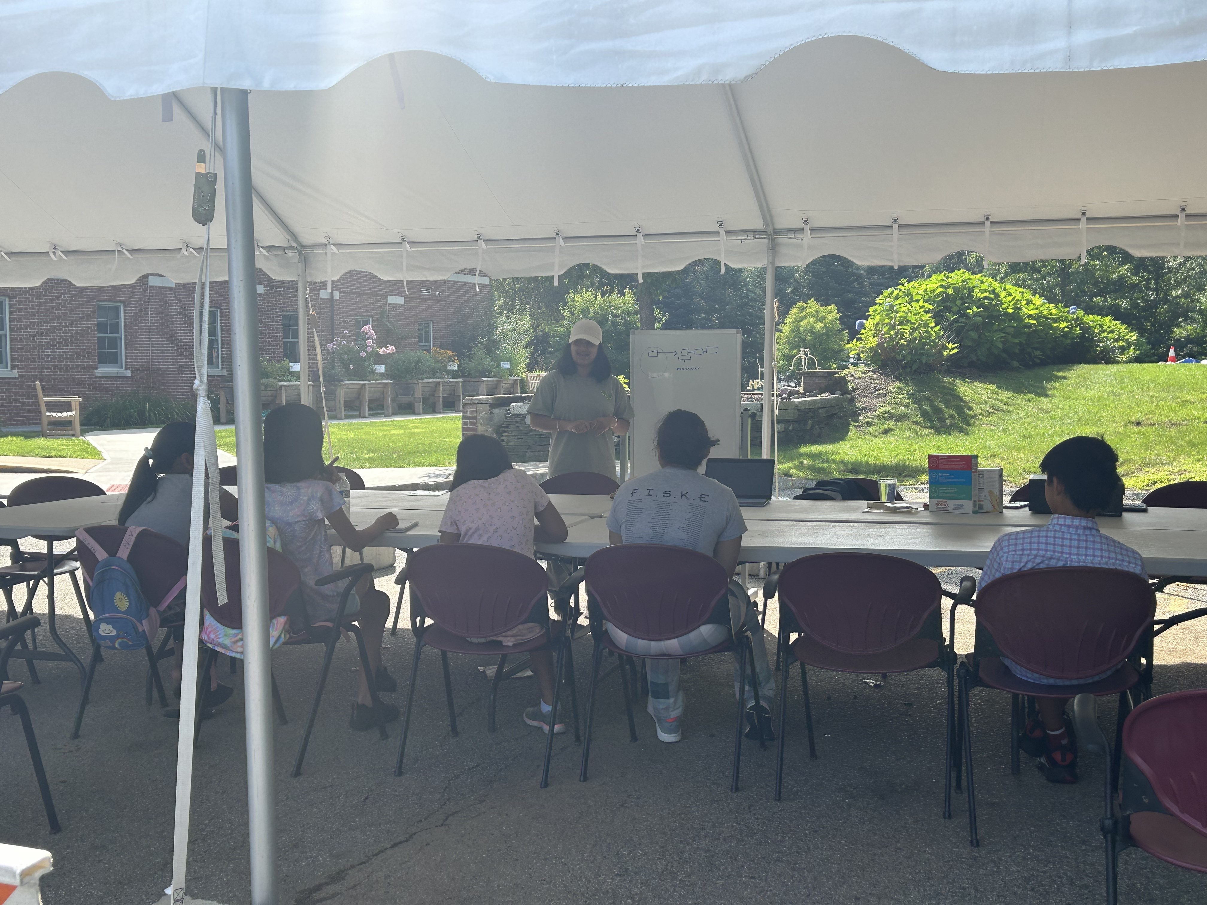 Students sitting under a tent, learning during Science Outdoors Season 3